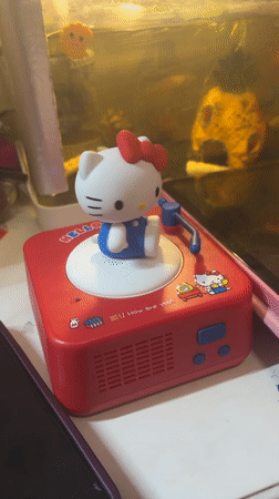 Hello Kitty figurine spins atop a miniature toy record player