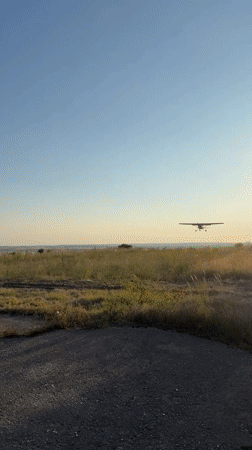 Active landing and abandoned biplane at a quiet Bulgarian airfield