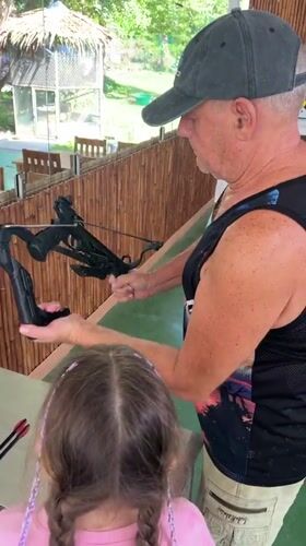 Woman teaches girl target shooting at Thailand recreational facility