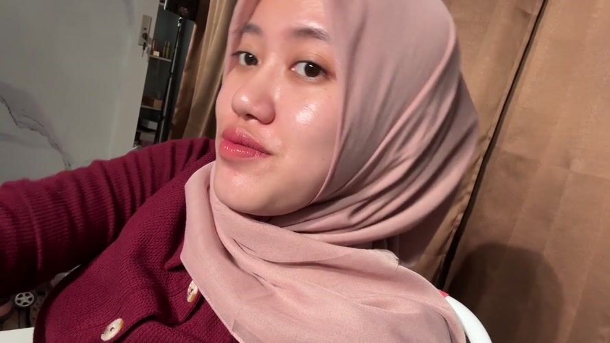 Woman in pink hijab photographed at home in Indonesia