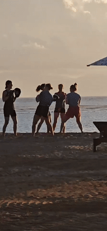 Evening beach activities documented in Denpasar: boxing training, selfies, dogs