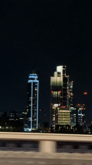 London skyline captured from moving vehicle on bridge at night