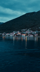 Waterfront town with white buildings documented at dusk