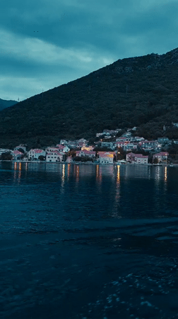 Waterfront town with white buildings documented at dusk