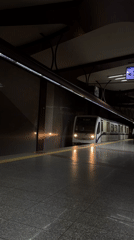Metro train arrives at underground station with safety markings