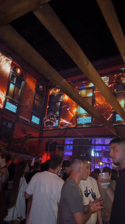 Odesa nightlife venue with bold wall projections and crowds