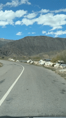 Vehicle drives mountain road in Çolpon-Ata, Kyrgyzstan