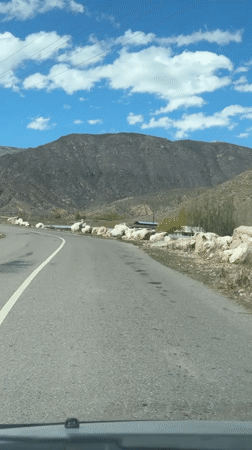 Vehicle drives mountain road in Çolpon-Ata, Kyrgyzstan