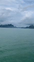 Ferry crosses waters near Thong Nian under cloudy skies