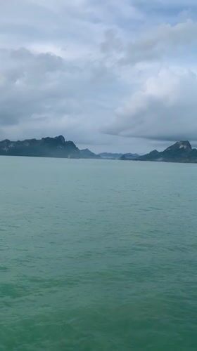 Ferry crosses waters near Thong Nian under cloudy skies