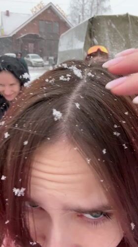 Young people take selfies during snowfall in Gory, Russia