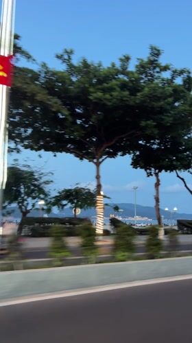 Vehicle travels coastal road in Nha Trang during evening hours