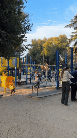 Families enjoy playground time as sunset paints Andes Mountains
