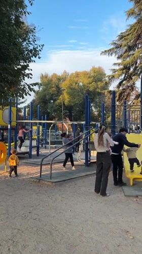 Families enjoy playground time as sunset paints Andes Mountains