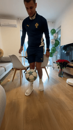 Man practices soccer juggling indoors in Montenegro living room