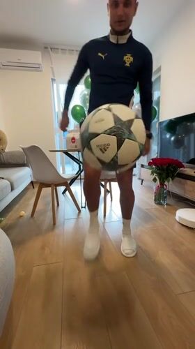 Man practices soccer juggling indoors in Montenegro living room
