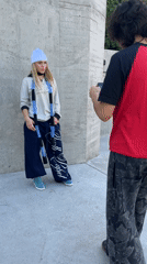 Young people photograph each other at concrete wall in Bahía Blanca