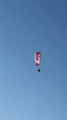 Paragliders soar over Fethiye beaches during afternoon flight session
