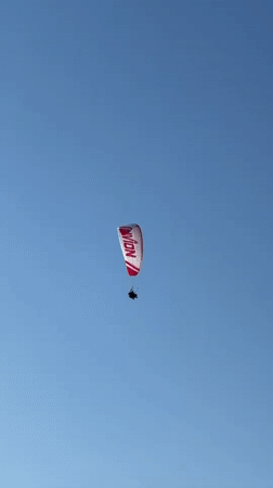 Paragliders soar over Fethiye beaches during afternoon flight session