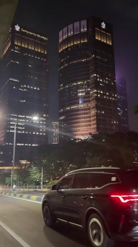 Black SUV drives past office buildings in South Jakarta
