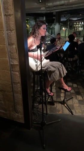 Solo electric guitar performance against a brick wall in Barcelona