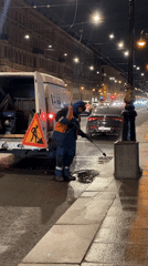 Worker pressure-washes stone sculptures on Saint Petersburg street