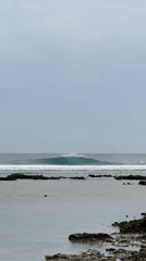 Clean reef wave breaking under gray skies in General Luna