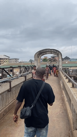 Pedestrian crosses busy urban bridge in Onitsha, Nigeria