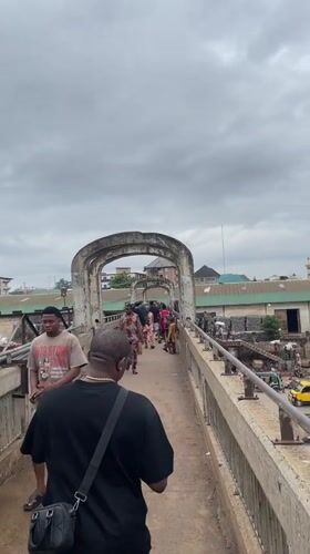 Pedestrian crosses busy urban bridge in Onitsha, Nigeria