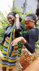 Two women dance outdoors in Gwong, Nigeria