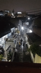 Rainy night in Bandung: alleyways, parked bikes, a sheltering vendor