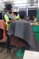 Inside a Dhaka barbershop during an afternoon haircut