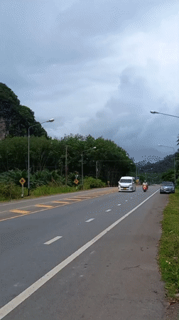 Morning traffic flows past karst cliffs in Khao Khram
