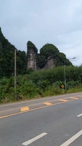 Morning traffic flows past karst cliffs in Khao Khram