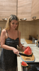 Woman enjoys watermelon snack in Budva kitchen