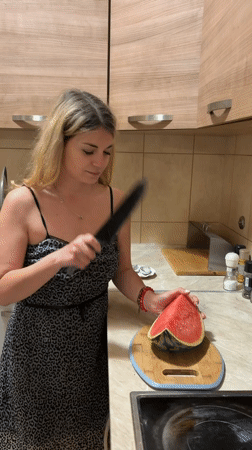 Woman enjoys watermelon snack in Budva kitchen