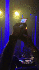 DJ performs for dancing crowd at nightclub event