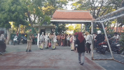Group in traditional dress gathers outdoors in Surabaya