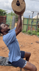 Man works out with homemade weights in Akwanga outdoor gym