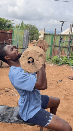 Man works out with homemade weights in Akwanga outdoor gym