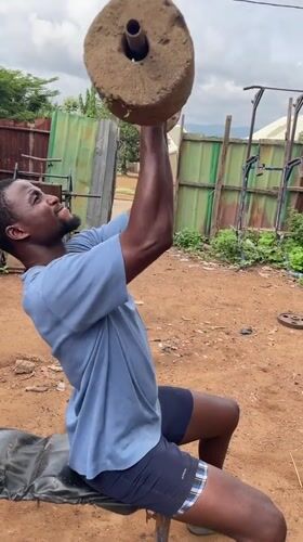 Man works out with homemade weights in Akwanga outdoor gym