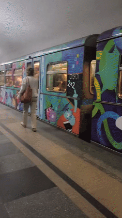 Decorated subway train departs historic station with gold 1946 relief
