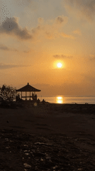 Bali beach at golden hour — canoes, boats, and shoreline life