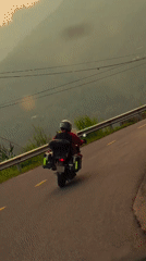 Motorcyclist with passenger travels mountain road in Vietnam