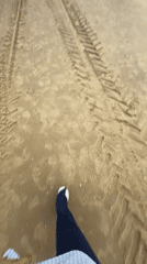 Beachgoer walks sandy shores in Herzliya under cloudy skies