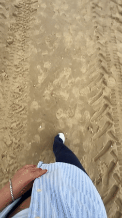 Beachgoer walks sandy shores in Herzliya under cloudy skies
