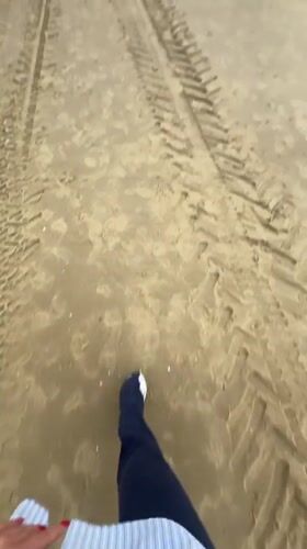 Beachgoer walks sandy shores in Herzliya under cloudy skies