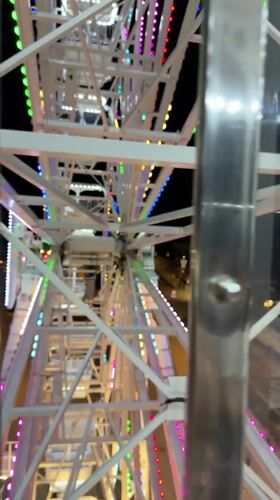 Ferris wheel spinning under summer night lights in Gatteo