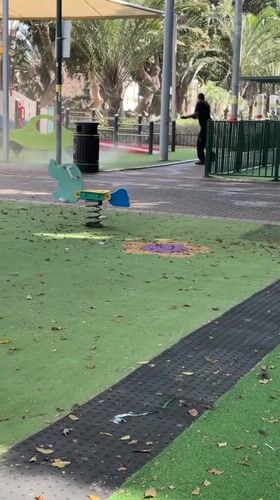 Man operates sprayer producing white mist in Netanya park