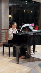 Woman plays grand piano in Bangkok lobby